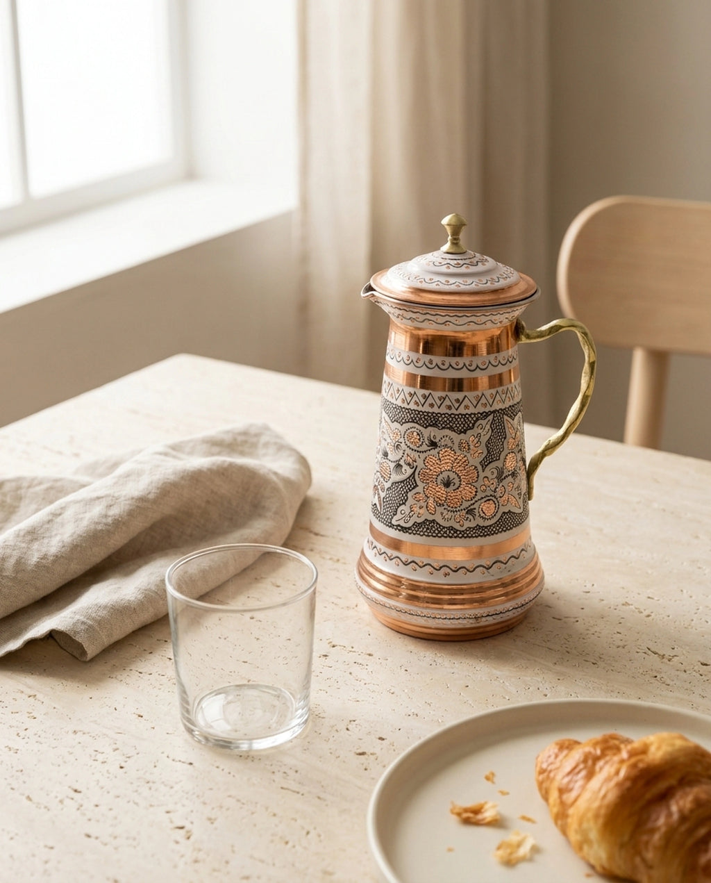 Kahvaltı masasında, kruvasan ve cam bardak eşliğinde sunulan beyaz zeminli işlemeli bakır sürahi - Gaziantep Bakırcılık
