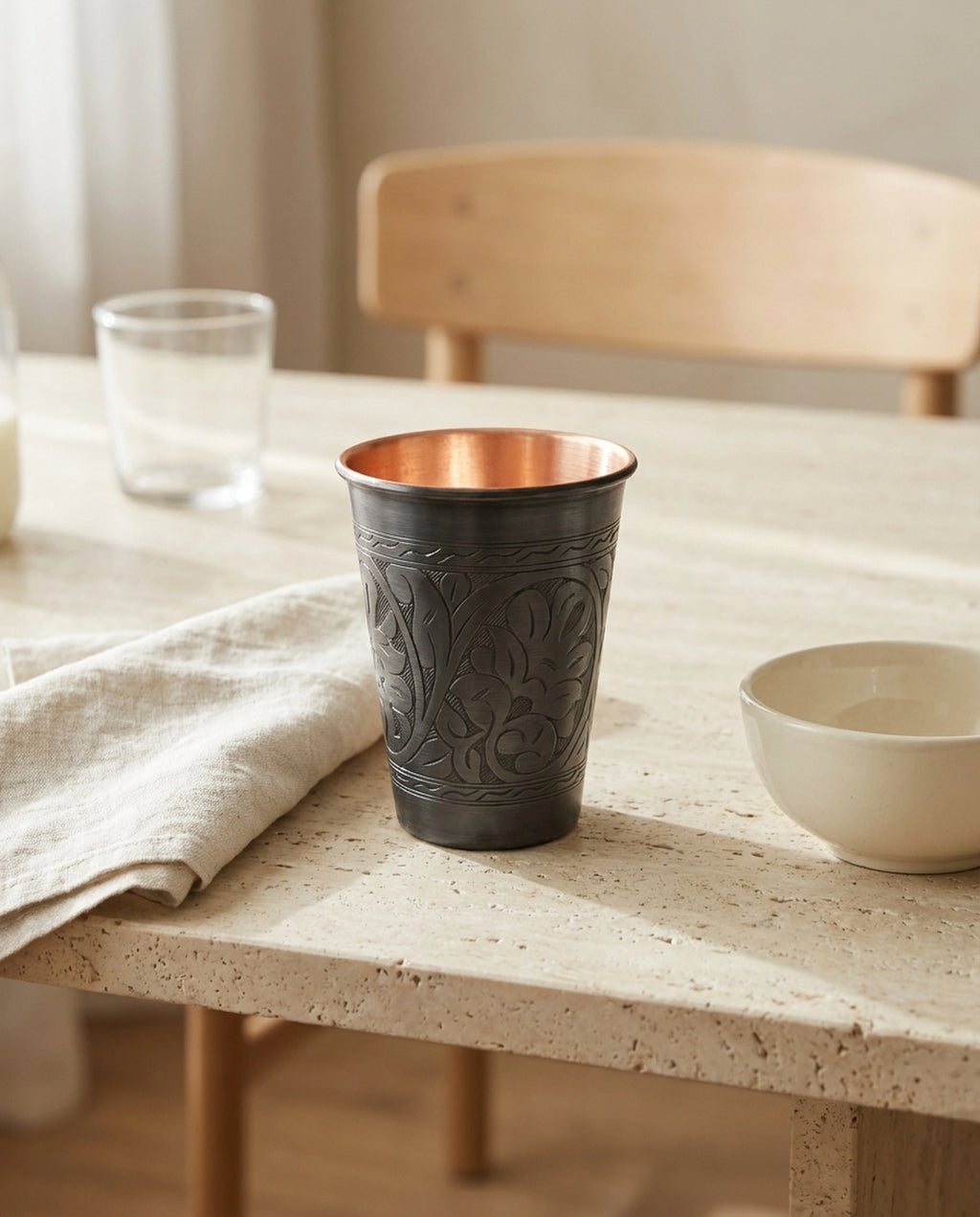Keten peçete ve seramik kase yanında ahşap masada duran işlemeli bakır bardak. - Gaziantep Bakırcılık