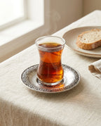Üzerinde ince belli bardakta çay bulunan işlemeli gümüş renk bakır çay altlığı sunumu. - Gaziantep Bakırcılık