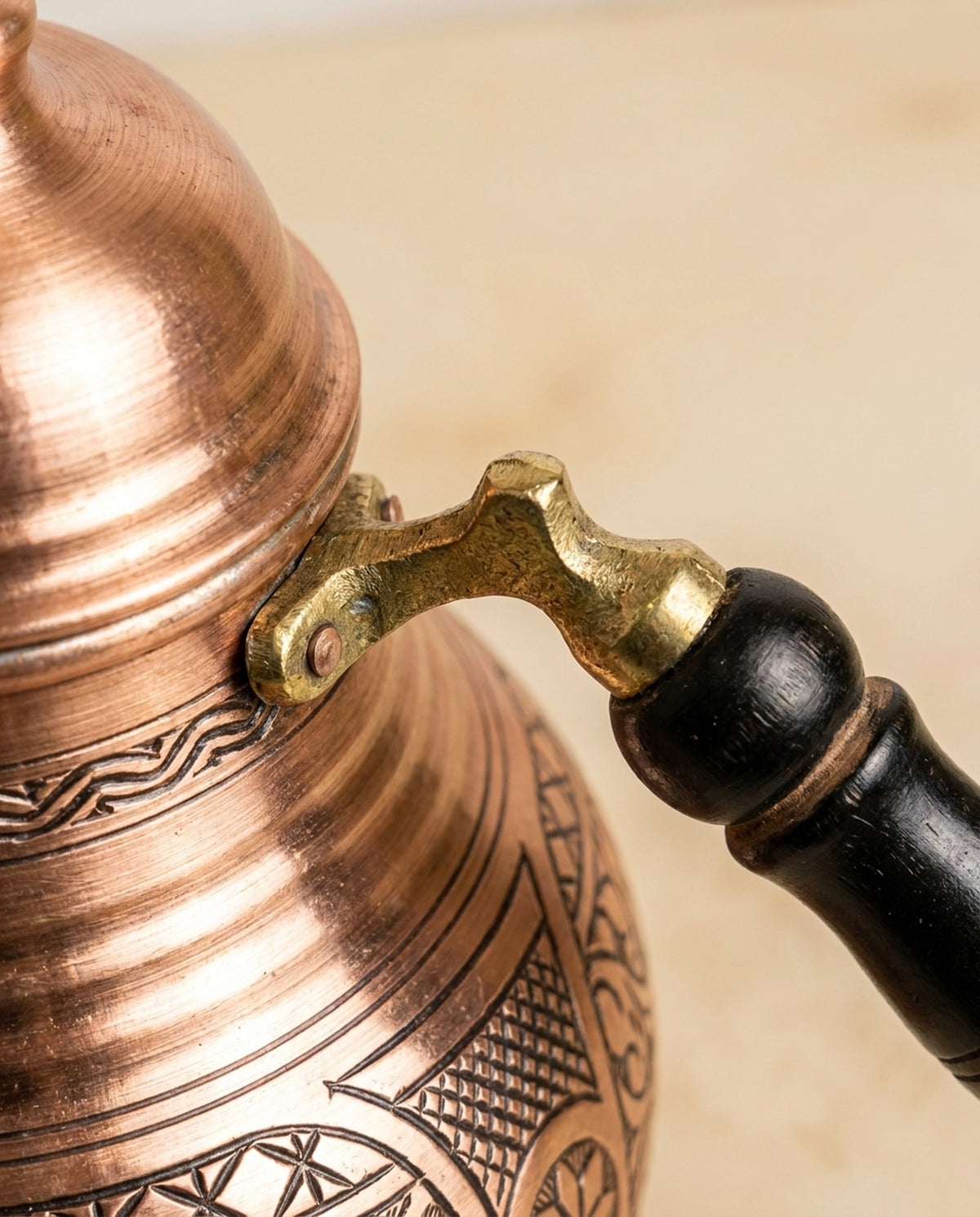 Bakır çaydanlığın pirinç bağlantılı ahşap kulbu ve gövdesindeki kalem işi tarama detayları. - Gaziantep Bakırcılık