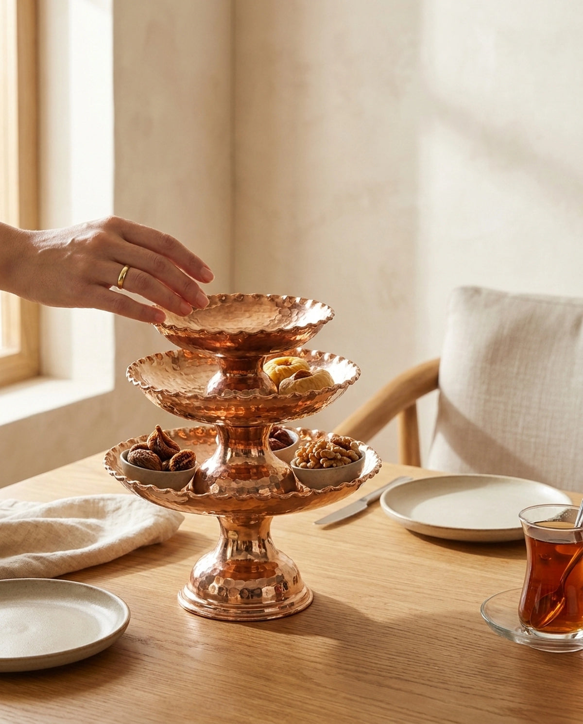 Çay ve atıştırmalıkların bulunduğu masada sunumluğa uzanan bir elin konsept görünümü. - Gaziantep Bakırcılık