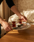İki kulplu gümüş kaplama bakır tepsi ile çay bardakları ve şekerliğin masaya servis edilme anı. - Gaziantep Bakırcılık