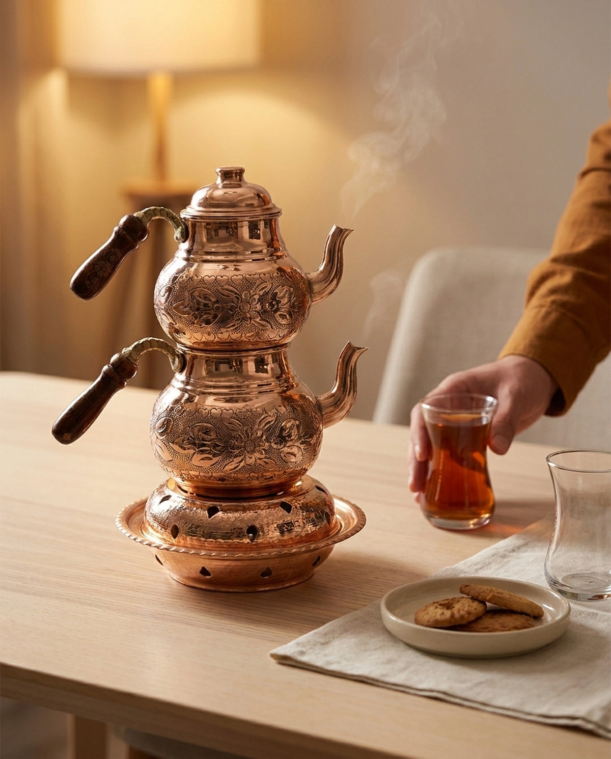 Kurabiye ve çay eşliğinde hazırlanan sofrada, buharı tüten reşolu bakır çaydanlık. - Gaziantep Bakırcılık