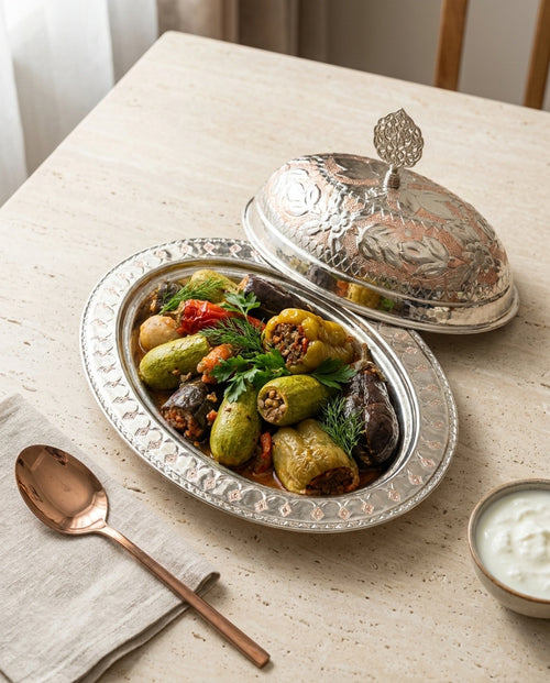 İçi dolma dolu, kapağı yarı açık çift renkli bakır kayık sunumluk masa üzerinde. - Gaziantep Bakırcılık