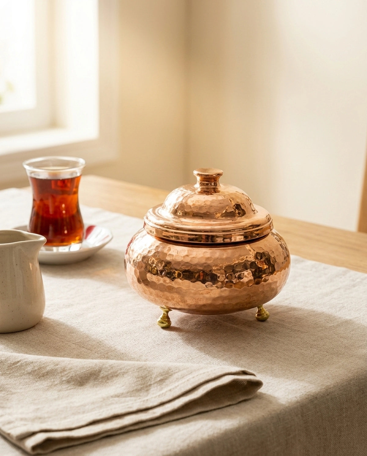 Masa üzerinde, çay bardağı eşliğinde sunulan kapaklı kızıl bakır şekerlik. - Gaziantep Bakırcılık