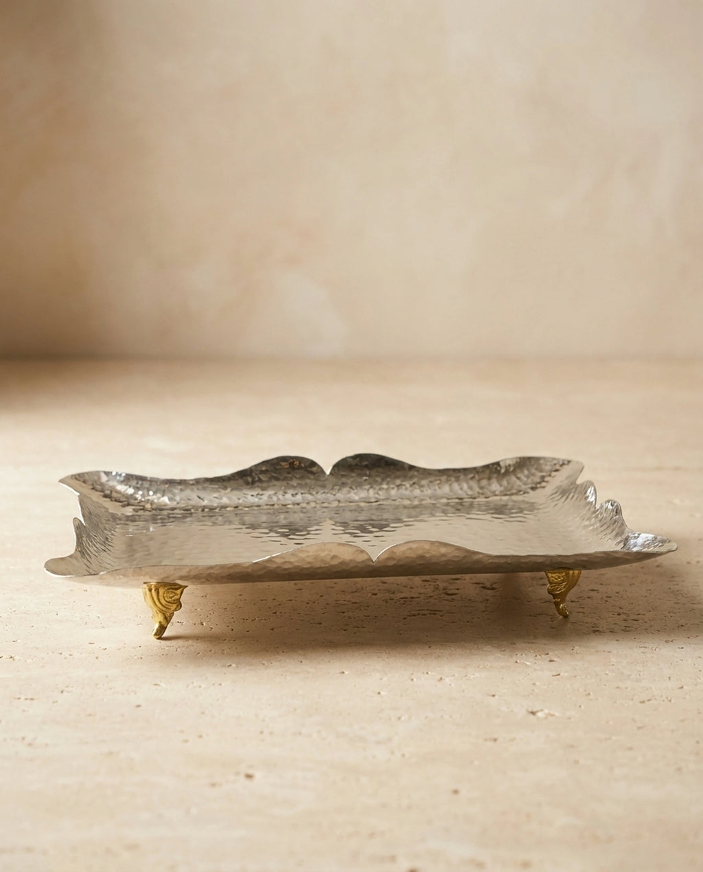 Dört pirinç ayaklı, dalgalı kenarlı el dövmesi beyaz bakır sunumluğun boş halinin önden görünümü. - Gaziantep Bakırcılık