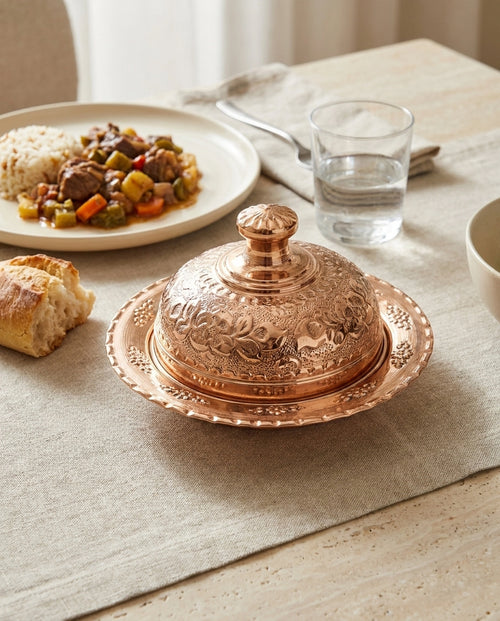 Sofrada kapalı halde duran, üzeri çiçek motifleriyle bezenmiş kubbe kapaklı kızıl bakır sahan - Gaziantep Bakırcılık