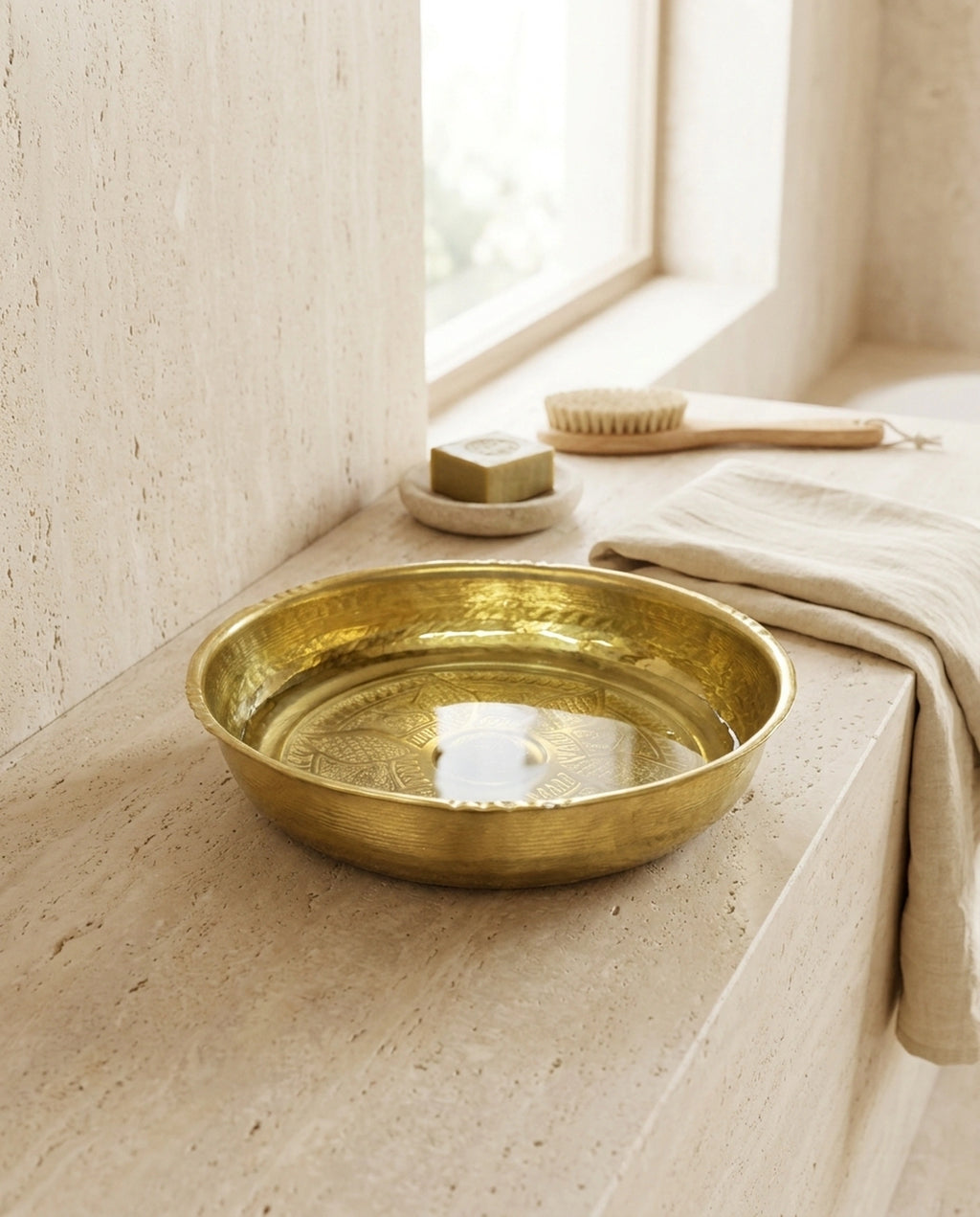Pencere önündeki taş zeminde su dolu bakır hamam tası, ahşap banyo fırçası ve havlulu atmosfer. - Gaziantep Bakırcılık