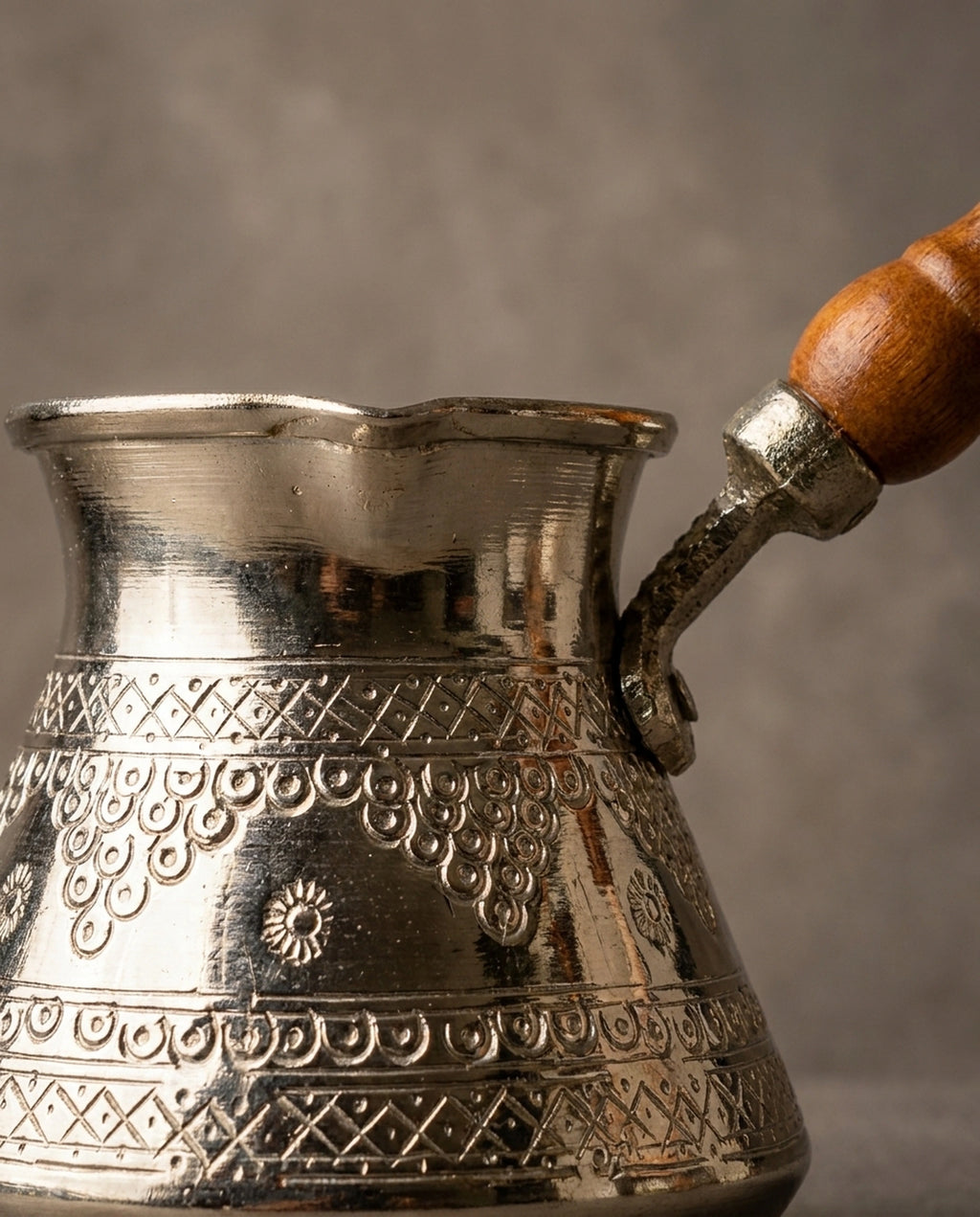 Bakır gövde üzerindeki zımba ve kalem işçiliği kabartma motiflerin ve kulp bağlantı detayı. - Gaziantep Bakırcılık