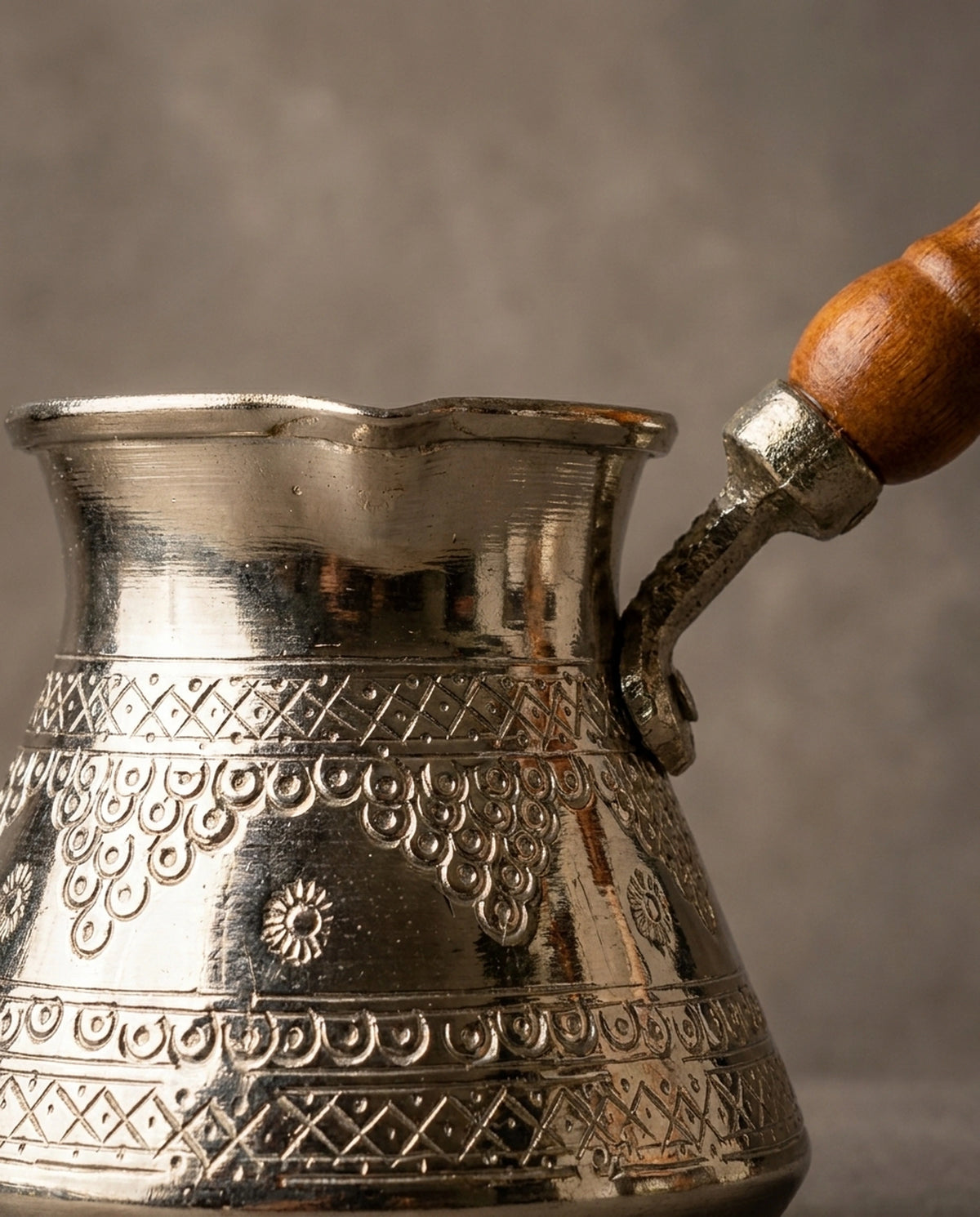 Bakır gövde üzerindeki zımba ve kalem işçiliği kabartma motiflerin ve kulp bağlantı detayı. - Gaziantep Bakırcılık