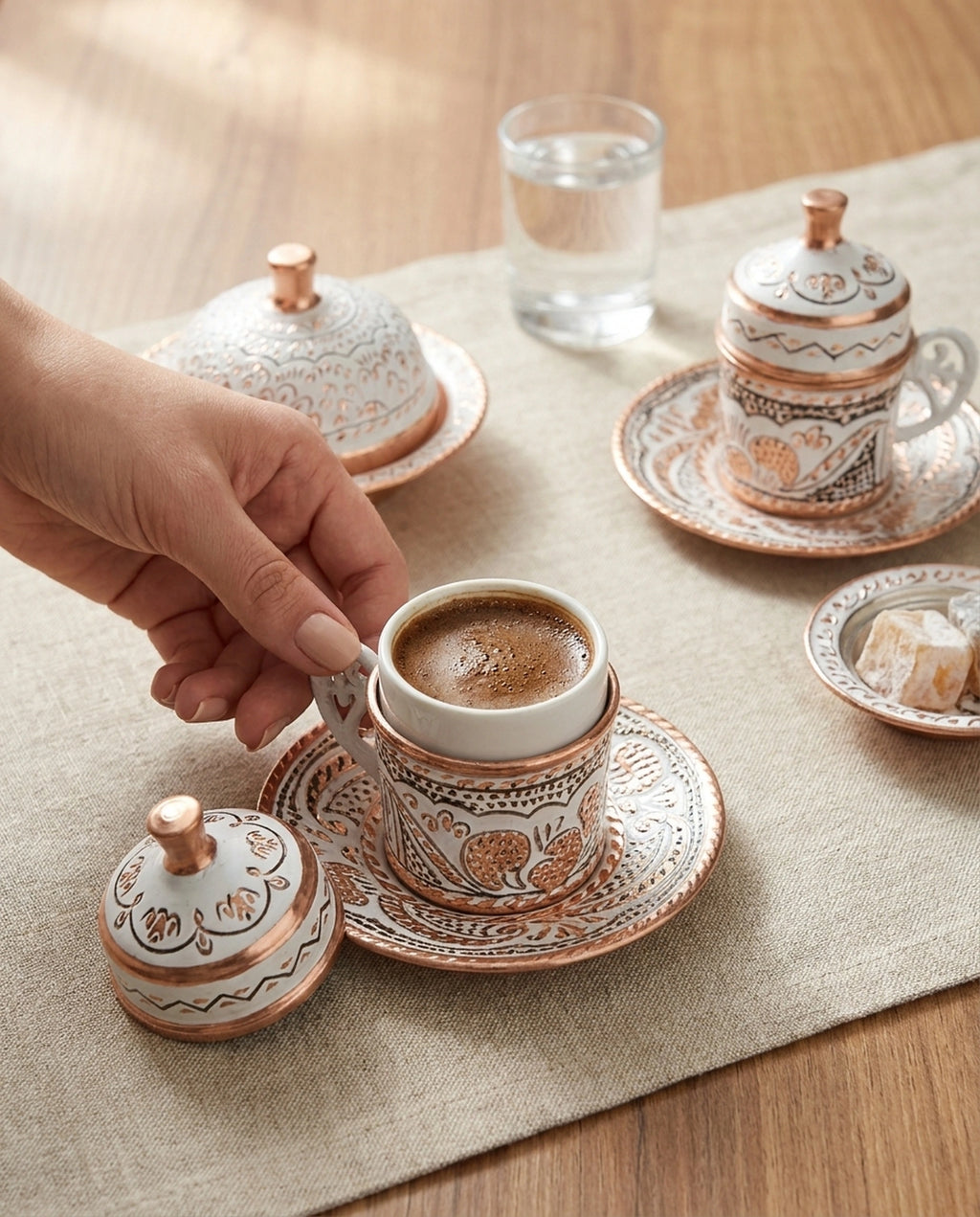 İçi köpüklü Türk kahvesi dolu beyaz bakır fincanın kapağı yanına bırakılmış yakın servis anı. - Gaziantep Bakırcılık