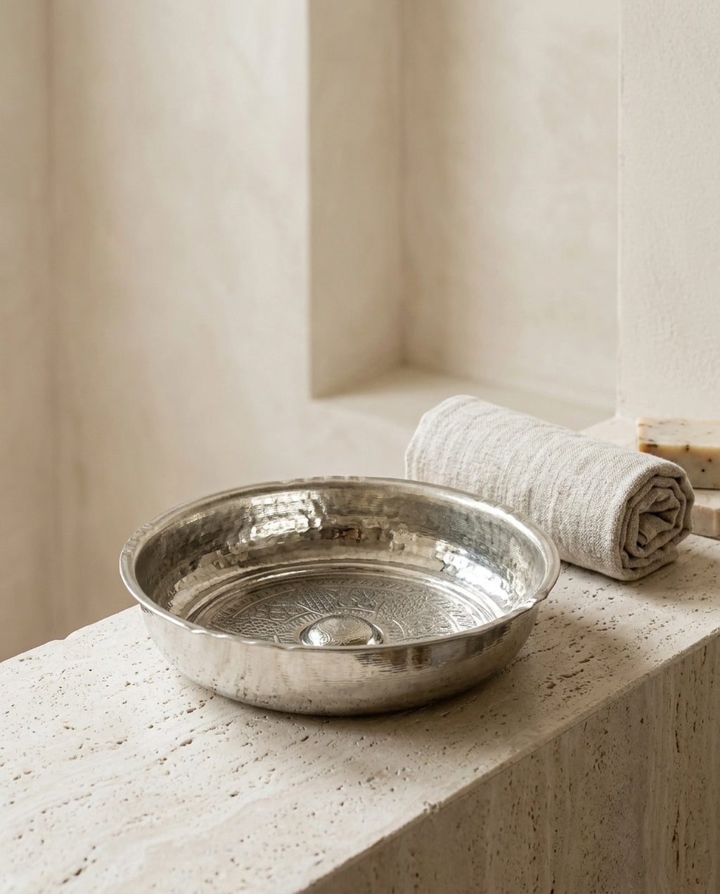 Taş kenarlık üzerinde duran işlemeli hamam tası, rulo havlu ve sabun ile birlikte. - Gaziantep Bakırcılık