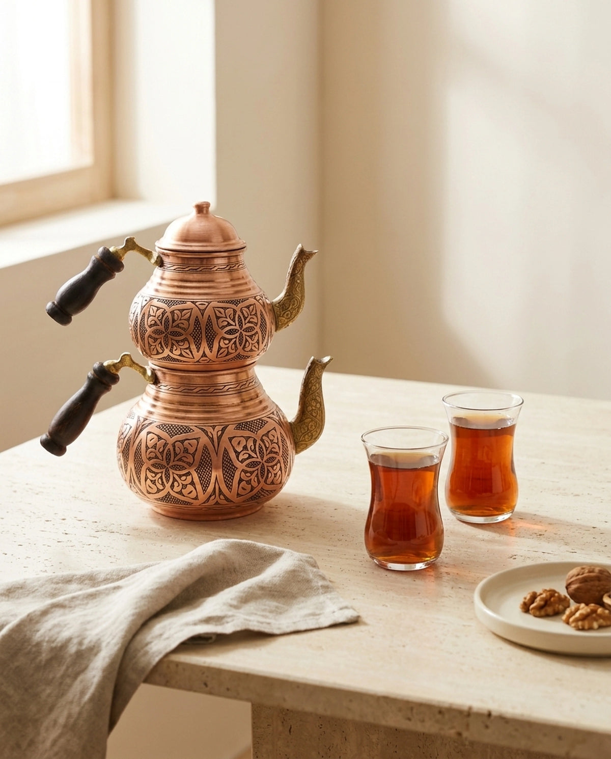 İki bardak çay ve ceviz tabağı ile mermer masada sunulan el işlemesi bakır çaydanlık. - Gaziantep Bakırcılık