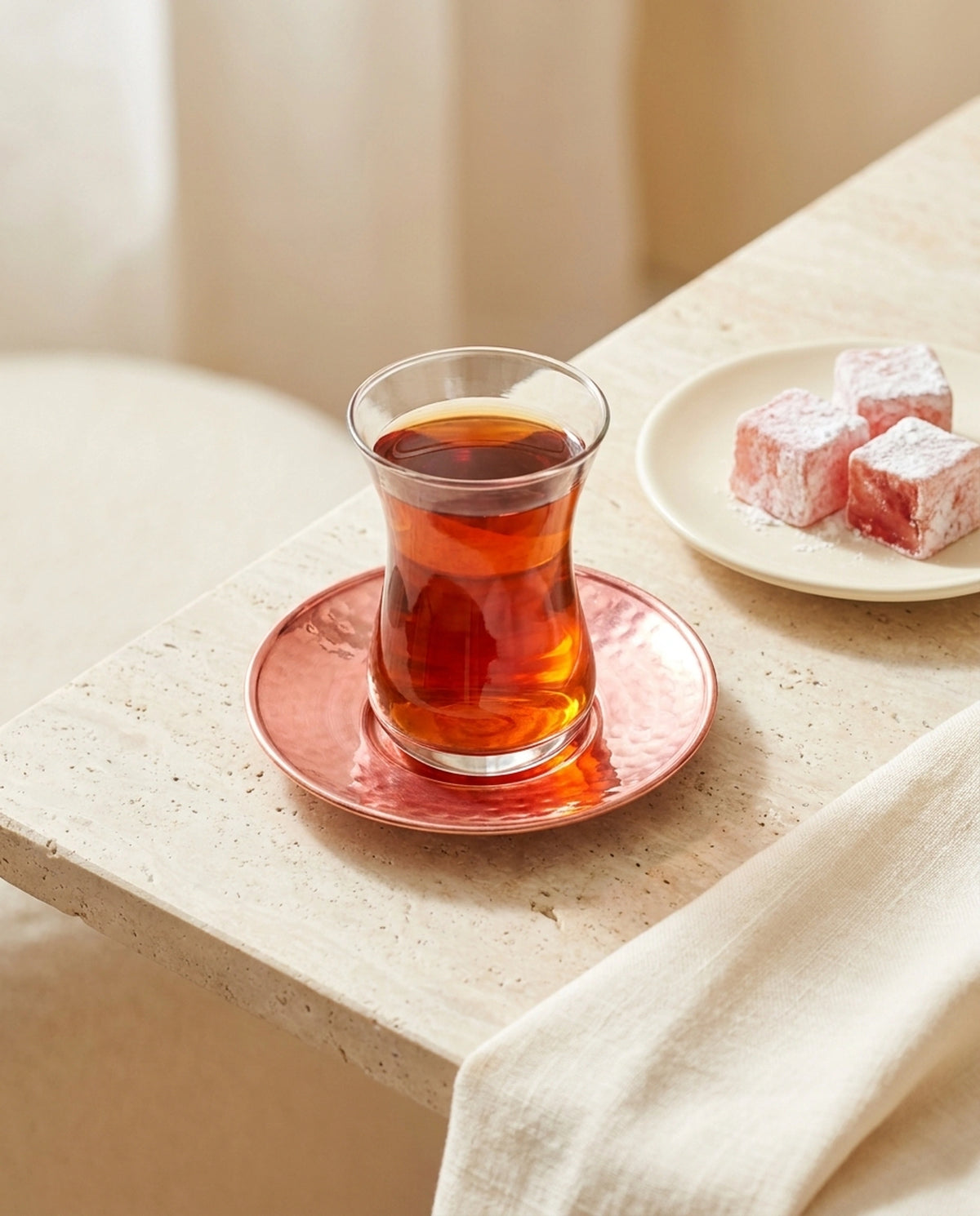 Taş zeminde bakır altlık üzerinde çay bardağı ve yanında tabak içerisinde lokum sunumu. - Gaziantep Bakırcılık