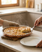 Mutfak tezgahında fırın eldiveniyle tutulan ve dilimlenmiş börek servis edilen bakır tepsi. - Gaziantep Bakırcılık