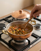 Ocak üzerinde kaynayan sulu yemeğin ahşap kaşıkla karıştırıldığı bakır sahan kullanımı - Gaziantep Bakırcılık
