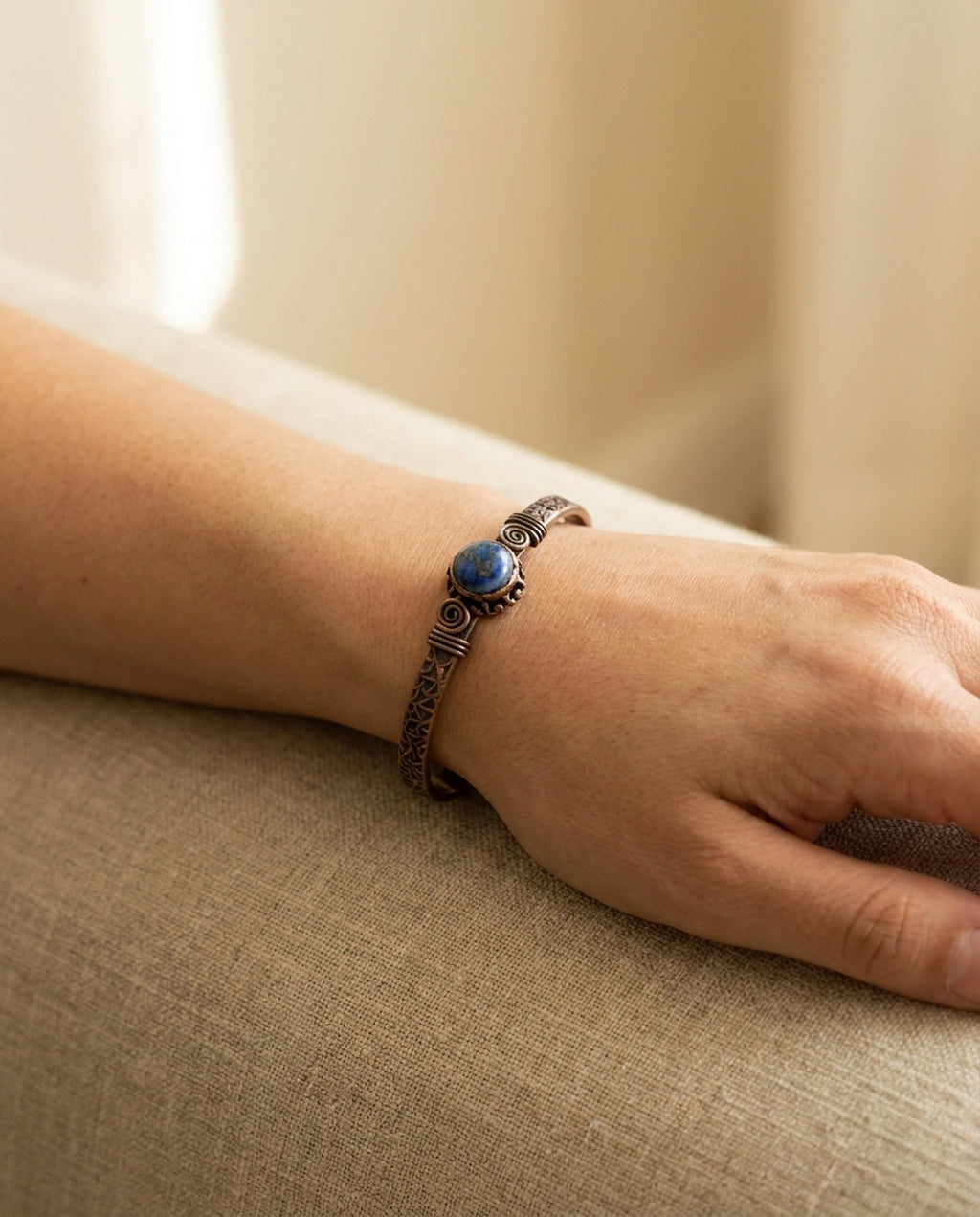 Modelin kolunda takılı halde duran Lapis Lazuli taşlı, spiral tel detaylı bakır bileklik. - Gaziantep Bakırcılık
