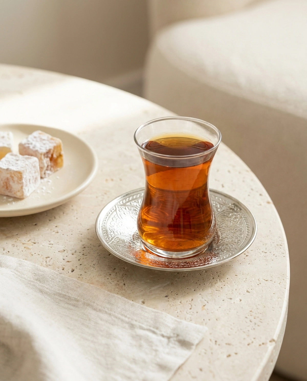 Taş masa üzerinde motifli bakır çay altlığı, demli çay ve yanında lokum ile şık sunum. - Gaziantep Bakırcılık