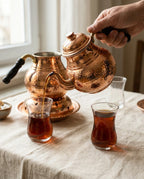 Bir elin bakır demlikten ince belli cam bardağa taze demlenmiş sıcak çay doldurduğu an. - Gaziantep Bakırcılık