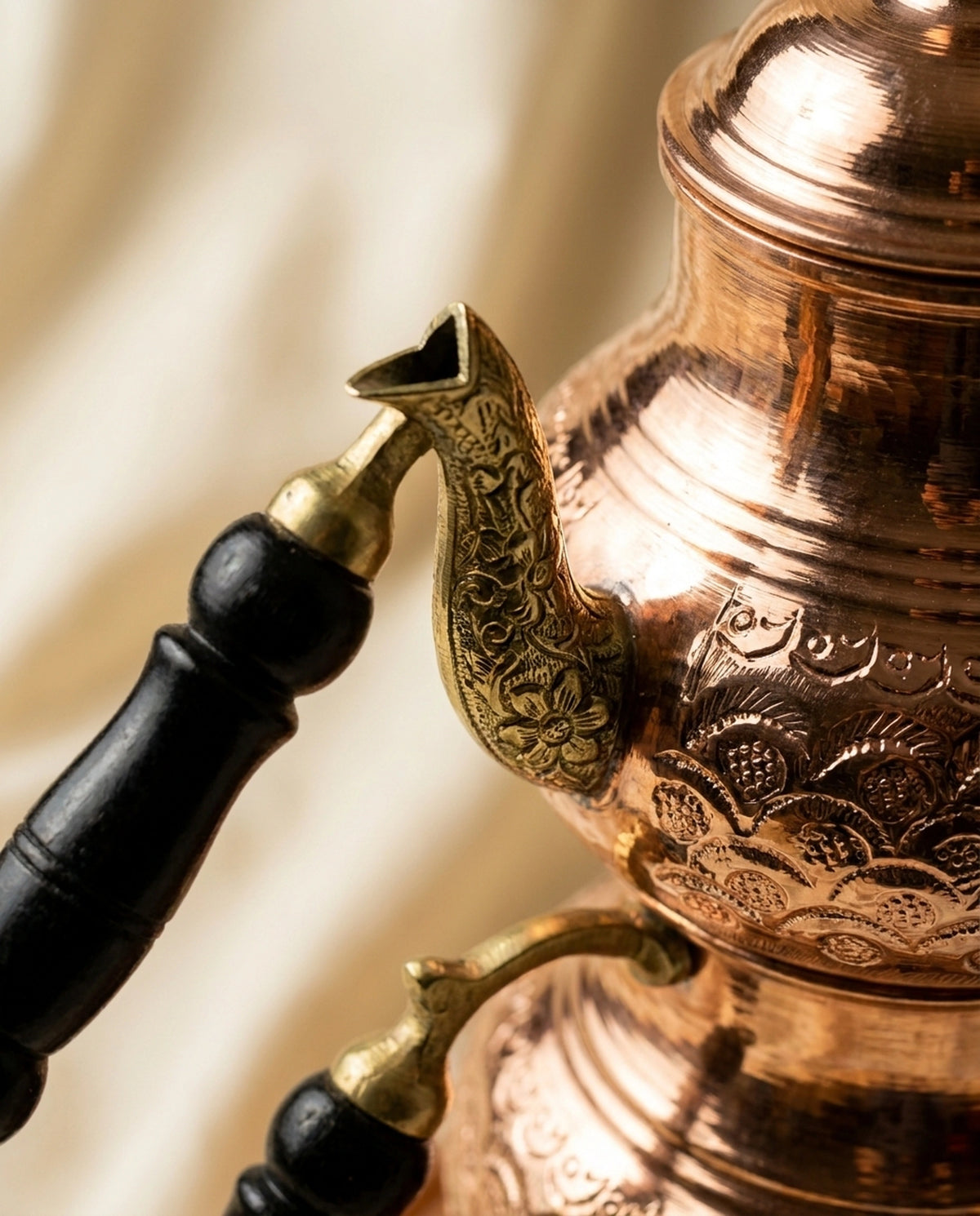 Bakır çaydanlığın ahşap kulp bağlantısı ve ince papatya motifleriyle işlenmiş döküm emzik detayı - Gaziantep Bakırcılık