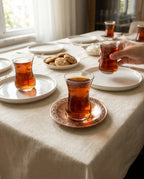 Kurulmuş bir çay sofrasında, kızıl bakır tabak üzerinde duran çay bardağı ve ikramlıklar. - Gaziantep Bakırcılık