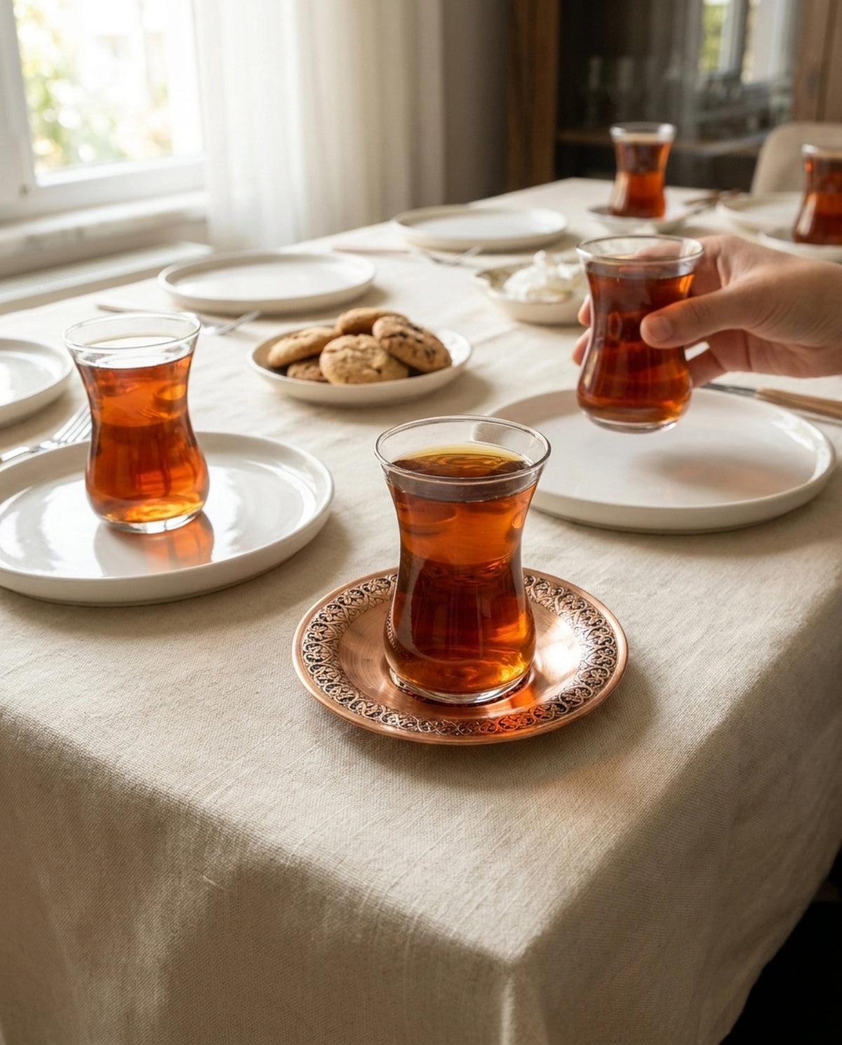 Kurulmuş bir çay sofrasında, kızıl bakır tabak üzerinde duran çay bardağı ve ikramlıklar. - Gaziantep Bakırcılık