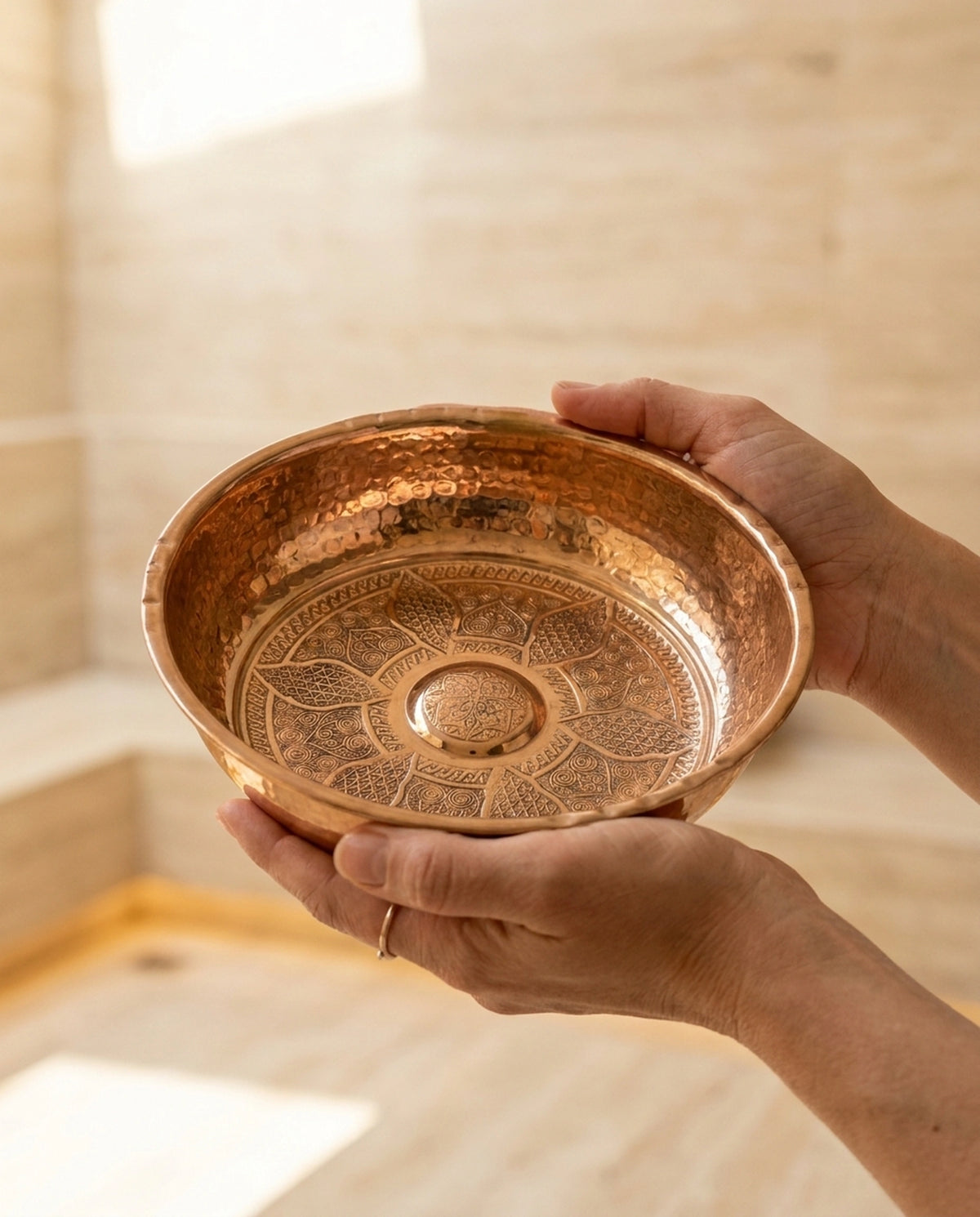 İki el ile tutulan, tabanında rumi motifler olan el dövmesi bakır hamam tası. - Gaziantep Bakırcılık